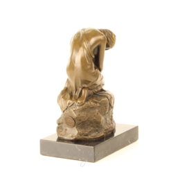 Bronzen beeldje van een dromend meisje op een rots