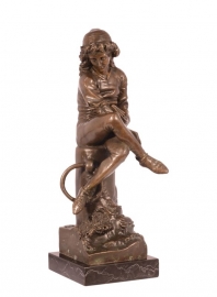 Bronzen beeld van jongen op paal