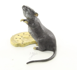 Een bronzen beeld van een muis met biscuit