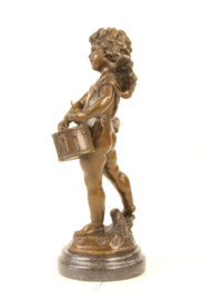 Bronzen beeld van putto spelend op zijn drum.