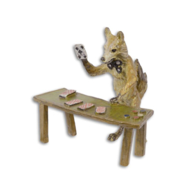 Een bronzen beeld van een vos met speelkaarten