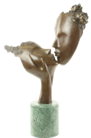 Bronzen beeld twee kussende gezichten.