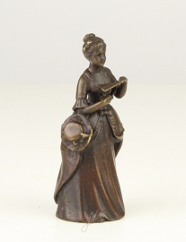 Een bronzen tafelbel vrouwenfiguur