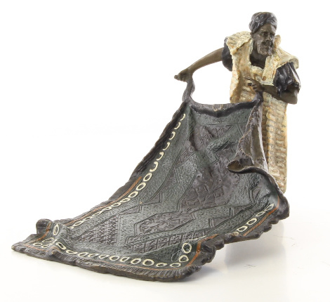 Een bronzen beeld van een Arabische tapijt verkoper