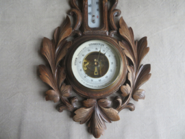 Oude barometer en thermometer in gestoken houten kast