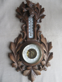 Oude barometer en thermometer in gestoken houten kast