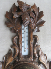 Oude barometer en thermometer in gestoken houten kast