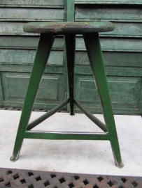 Old green metal stool with wooden seat
