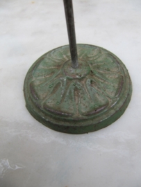 Oude metalen bonnenprikker rond gietijzeren voetje