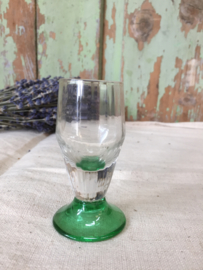 Oud glaasje op groene voet