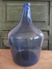 Oude glazen fles in blauw