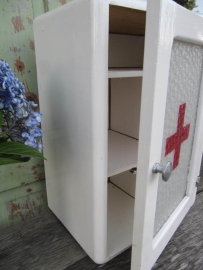 Oud medicijnkastje met glas en rood kruis