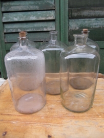 Ancient brocante clear glass bottle of about 10 liters