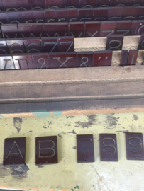 Oude industriële kist met graveerletters/cijfers