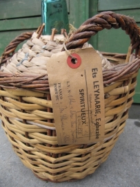 Brocante bottle in a basket with label and sealing wax on the cap