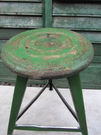Old green metal stool with wooden seat
