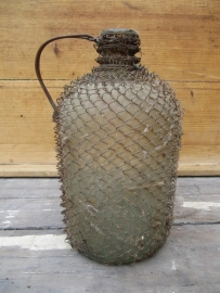 Old bottle with wire mesh and metal handle