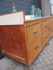 Oude beukenhouten mobiele werktafel of toonbank met 10 lades