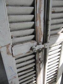 Antique double louvered doors set with espagnolette closure.
