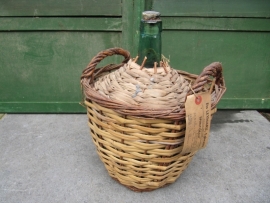 Brocante bottle in a basket with label and sealing wax on the cap