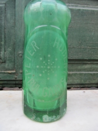 Oude groene spuitfles met opschrift