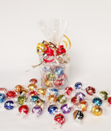 Glazen pot met opschrift: Enjoy the little things, gevuld met Lindt ballen