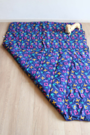 Vintage slaapzak met  jaren 90 patroon. Retro sprei/deken in gele tas