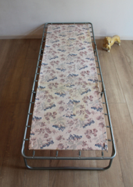 Vintage stretcher met bloemen. Retro veldbed / opklap bed