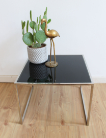 Vintage bijzettafel met zwart glazen blad. Retro design tafeltje