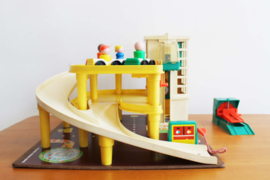 Vintage Fisher-Price garage met auto's en poppetjes.