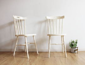 Set witte vintage spijlenstoelen. Twee houten retro stoelen.