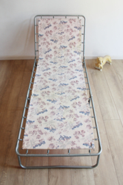 Vintage stretcher met bloemen. Retro veldbed / opklap bed