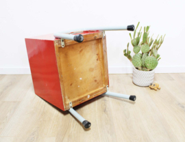 Rozig rood retro nachtkastje. Houten vintage kastje op metalen poten
