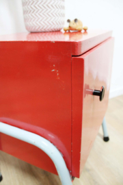 Rozig rood retro nachtkastje. Houten vintage kastje op metalen poten