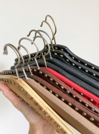 9 vintage kledinghangers van skai leer. Set retro kleerhangers o.a. met studs