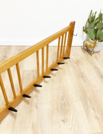 Vintage wandkapstok met zwarte haken. Houten retro kapstok