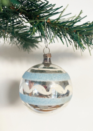 Zilveren glazen vintage kerstbal met licht blauwe streepjes.