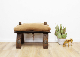 Vintage kamelenzadel kruk met bruin kussen. Houten Boho voetenbankje