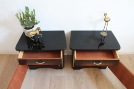 Set houten vintage nachtkastjes met zwart glas. Twee Art Deco stijl retro kastjes