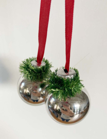 Zilveren kerstballen aan rood lint. Vintage kerstdecoratie.