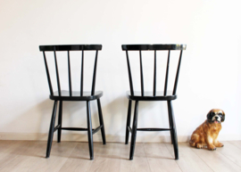Set zwarte vintage spijlenstoelen. 2 houten retro stoelen.