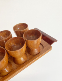 8 houten vintage eierdopjes op plateau. Retro eierdoppen