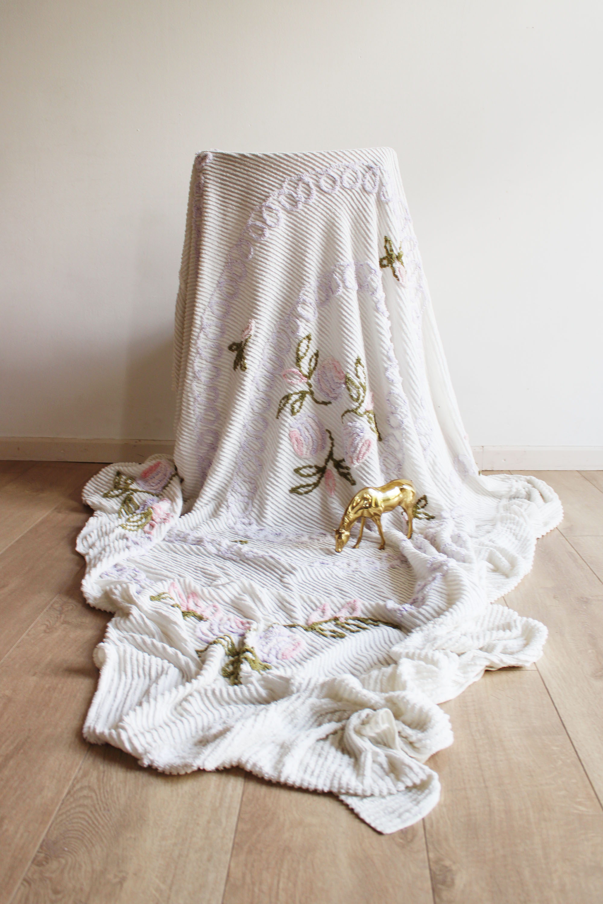 Witte vintage chenille sprei met bloemen. Retro sierdeken.