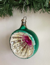 Groene vintage deukbal met paarse binnenkant. Glazen retro kerstbal