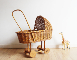 Rieten vintage wandelwagen voor de pop. Retro poppenwagen.Schattig vintage poppenwagentje .