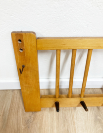 Vintage wandkapstok met zwarte haken. Houten retro kapstok