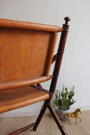 Houten vintage klapstoel. Antieke opvouwbare stoel met lederen zitting.