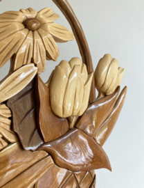 Houten ornament in de vorm van een mand met bloemen. Vintage reliëf