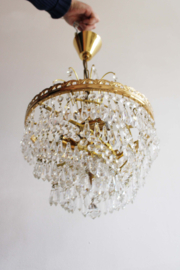 Goudkleurige kroonluchter met pegels in swirl. Hollywood Regency hanglamp