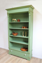 Goene vintage boekenkast. Houten keukenkast met planken en lade